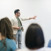 Leadership coach demonstrating communication hacks to a group of professionals during a team workshop.